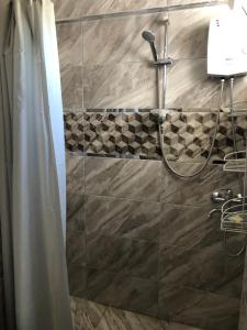 een douche in een badkamer met een douchegordijn bij Selkent in Kıyıkışlacık