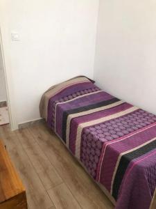 łóżko w pokoju z fioletowym kocem w obiekcie Selkent w mieście Kıyıkışlacık