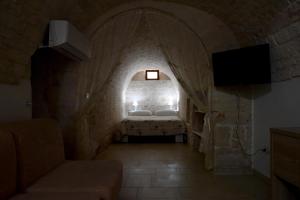 ein kleines Zimmer mit einem Bett in einer Steinmauer in der Unterkunft Agape fra i Trulli Dimora Ciclamino in Alberobello