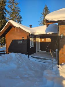 ein Haus mit Schnee auf dem Dach in der Unterkunft Hytte i Ringsaker (Ljøsheim/Sjusjøen) in Ringsaker
