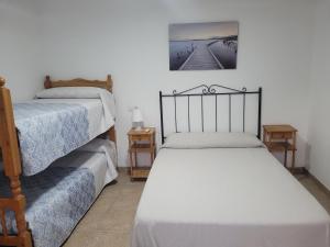 1 dormitorio con 2 camas y una foto en la pared en La Llar de Laura, en El Poblenou del Delta