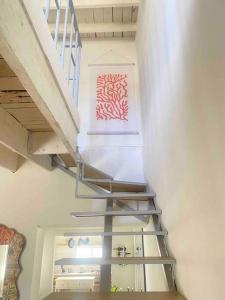 una escalera de metal en una habitación con una pintura en la pared en PV. Studio 3 ppl, centro, tiny house, 1 habitacion, en Chihuahua
