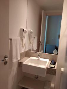 y baño con lavabo blanco y espejo. en Quarto Design Linhares 507, en Linhares