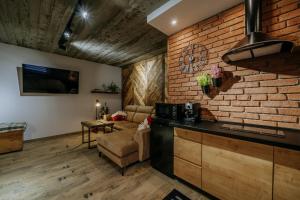 a kitchen and living room with a brick wall at Wierch Głodowski 25D by Homeprime in Bukowina Tatrzańska