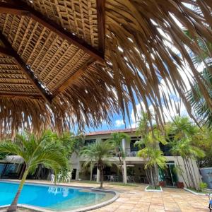 a resort with a swimming pool with palm trees at Hotel Praia Bela in Salinópolis