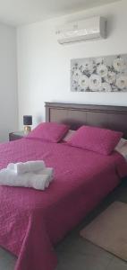 - un lit violet avec 2 serviettes blanches dans l'établissement Jade Aparts Salinas, à Salinas