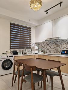 a kitchen with a wooden table and chairs in it at Cityscape Haven - Explore George Town, Komtar & UNESCO in Jelutong