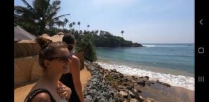 希卡杜瓦的住宿－RM Holiday Home，站在海边的女人