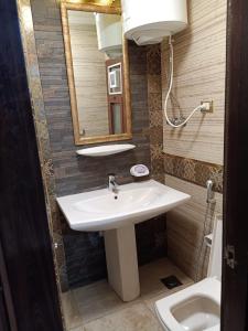 y baño con lavabo, espejo y aseo. en Apartment Porto El Sokhna Pyramids en Ain Sokhna