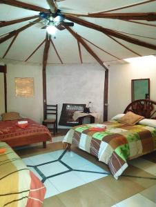a bedroom with two beds and a ceiling fan at Alojamiento Sumak Kawsay in Puerto Ayora