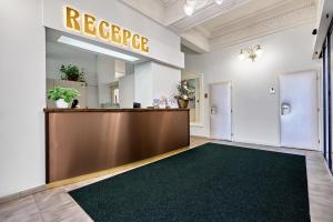 eine Rezeption in einer Lobby mit einem grünen Teppich in der Unterkunft Hotel Maxim in Marienbad