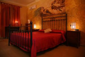 a bedroom with a bed with a red bedspread at Hotel Villa Antica Tropea in Tropea