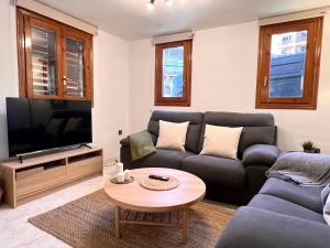 a living room with a couch and a tv at Can Florido - L'Amfitriona in Sort