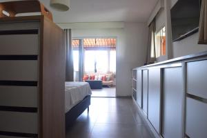 um quarto com uma cama e uma sala de estar em Casa de Lala Beach House em São Miguel do Gostoso