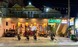 eine Gruppe von Motorrädern, die nachts vor einem Haus geparkt werden in der Unterkunft T'H Homestay in Mui Ne