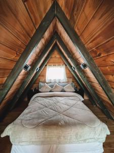 Bett in einem Zimmer mit Holzdecke in der Unterkunft Chalé em Alfredo Wagner in Alfredo Wagner