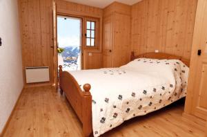 a bedroom with a bed and a large window at Verbier: Chalet avec vue magnifique in Verbier