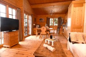 a living room with a television and a dining room at Verbier: Chalet avec vue magnifique in Verbier