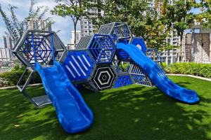 a playground with a blue slide on the grass at Cityscape Haven - Explore George Town, Komtar & UNESCO in Jelutong