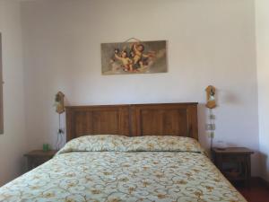 ein Bett in einem Schlafzimmer mit zwei Nachttischen und einem Bild an der Wand in der Unterkunft Albergo Villa Sorriso in Fiesole