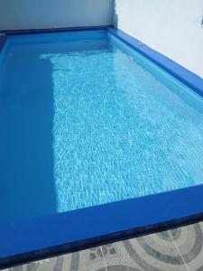 een zwembad met blauw water in een kamer bij Casa para la familia in Boca Chica