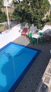 a blue swimming pool with a table and chairs at Casa para la familia in Boca Chica