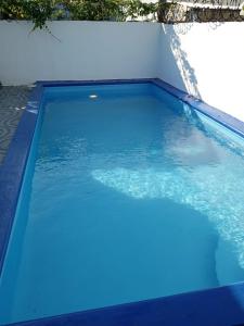 a swimming pool with blue water in a backyard at Casa para la familia in Boca Chica