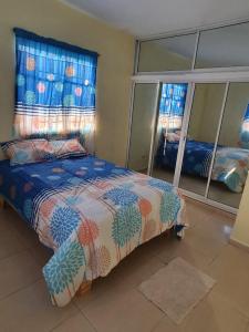 um quarto com uma cama e um espelho grande em Casa para la familia em Boca Chica