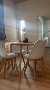 Cozy Appartement Hagen في هاغين: طاولة طعام مع كراسي و مزهرية عليها