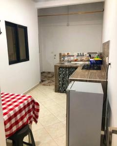 een keuken met een rood en wit geruite tafelkleed bij Apto Tomás in Doradal