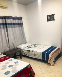 een slaapkamer met 2 aparte bedden en een gordijn bij Apto Tomás in Doradal