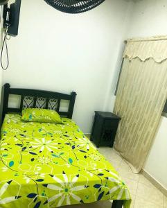 een slaapkamer met een bed met een geel dekbed bij Apto Tomás in Doradal