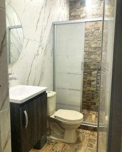 een badkamer met een toilet, een wastafel en een douche bij Apto Tomás in Doradal