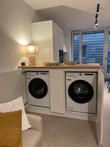a living room with two washing machines and a couch at Markt 5 in Lier