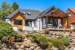 uma casa grande com um alpendre com um pátio de pedra em Green Lakefront Villa em Seattle