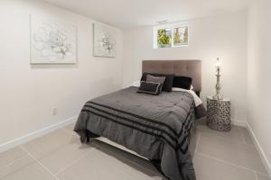 a white bedroom with a bed in a white room at Green Lakefront Villa in Seattle