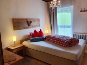 een slaapkamer met een bed met kussens en een raam bij Boutique Hotel Alpenhof in Sankt Martin am Tennengebirge
