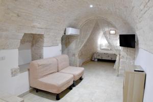 ein Wohnzimmer mit einem Stuhl in einer Steinmauer in der Unterkunft Agape fra i Trulli Dimora Ciclamino in Alberobello