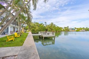 a person sitting on a dock in the water at Capri 109 in Marco Island