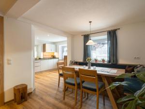 eine Küche und ein Esszimmer mit einem Tisch und Stühlen in der Unterkunft Gartenhaus Zur Kröllin in Mayrhofen