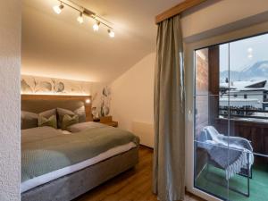 ein Schlafzimmer mit einem Bett und einem großen Fenster in der Unterkunft Gartenhaus Zur Kröllin in Mayrhofen