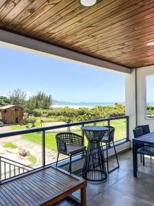 un patio con mesas y sillas y vistas al océano en Gamboa Luna y Sol Apart-Hotel en Gamboa