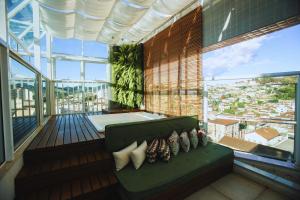 a balcony with a couch and a view of a city at Gontijo Inn Hotel in Itajubá