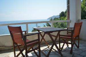 a wooden table and two chairs on a balcony at Country Art Studio Alkyoni in Kokkino Nero