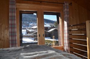 Schlafzimmer mit einem Bett und einem Fenster mit Aussicht in der Unterkunft Le Mazot Alice in Vercorin