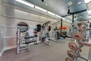 un gimnasio con varias cintas de correr y máquinas de ejercicio en Modern 2 Bedroom Apt , Pool, Gym, Parking Cs, en Dallas