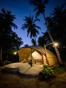 a large dome tent with a palm tree at night at The Por Beach in Ko Por