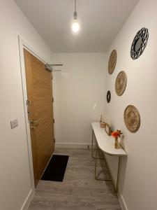 um quarto com um corredor com uma mesa e uma porta em Home Away em Swanscombe