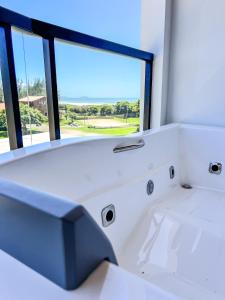 eine weiße Badewanne in einem Zimmer mit Fenster in der Unterkunft Gamboa Luna y Sol Apart-Hotel in Gamboa