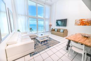 マイアミビーチにあるSeaStays Apartmentsのリビングルーム(白いソファ、テーブル付)